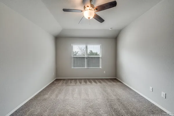 an empty room with a window and a fan