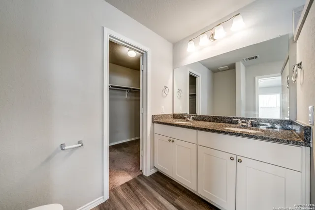 a bathroom with a granite countertop sink and a mirror