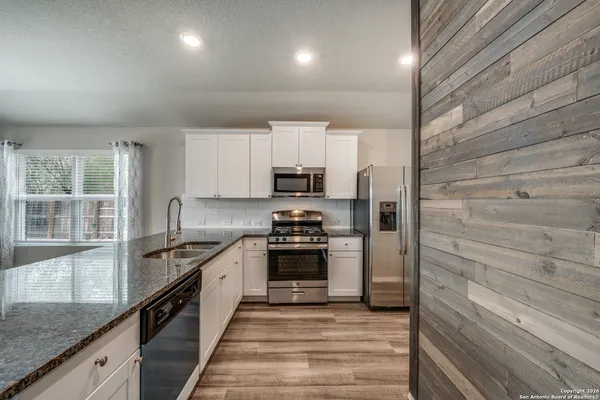 a kitchen with stainless steel appliances granite countertop a stove and a refrigerator