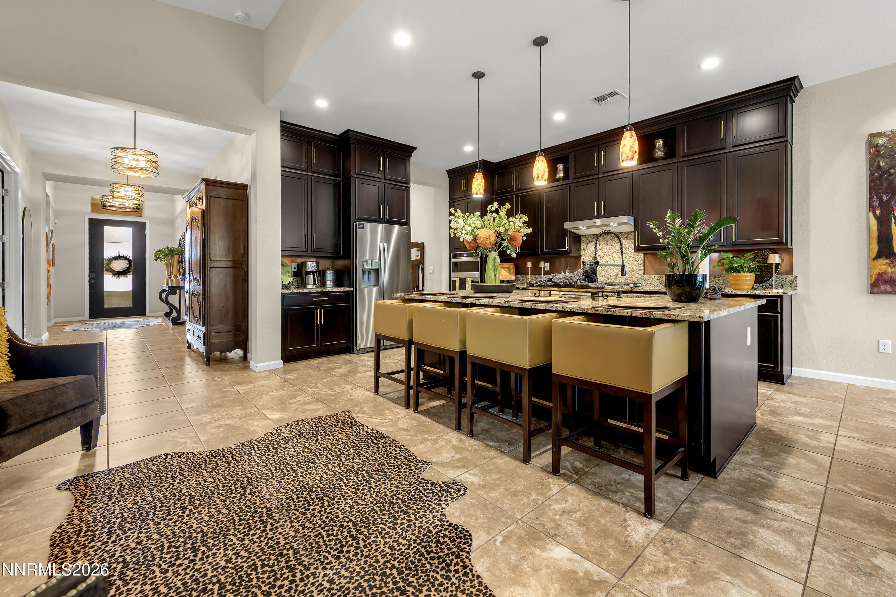 9021 Iron Sky Court Reno, NV 89523 - Photo 7 of 39 a kitchen with stainless steel appliances kitchen island granite countertop a refrigerator a stove a sink a dining table and chairs with wooden floor