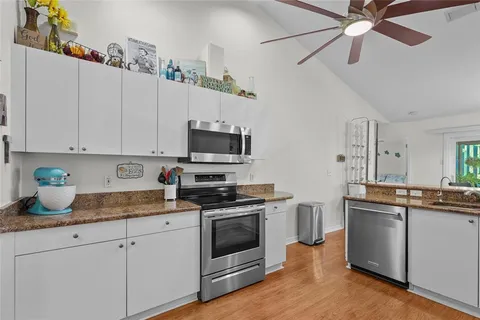 a kitchen with stainless steel appliances granite countertop a refrigerator a stove top oven a sink and dishwasher