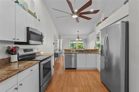 a kitchen with stainless steel appliances granite countertop a sink and a refrigerator