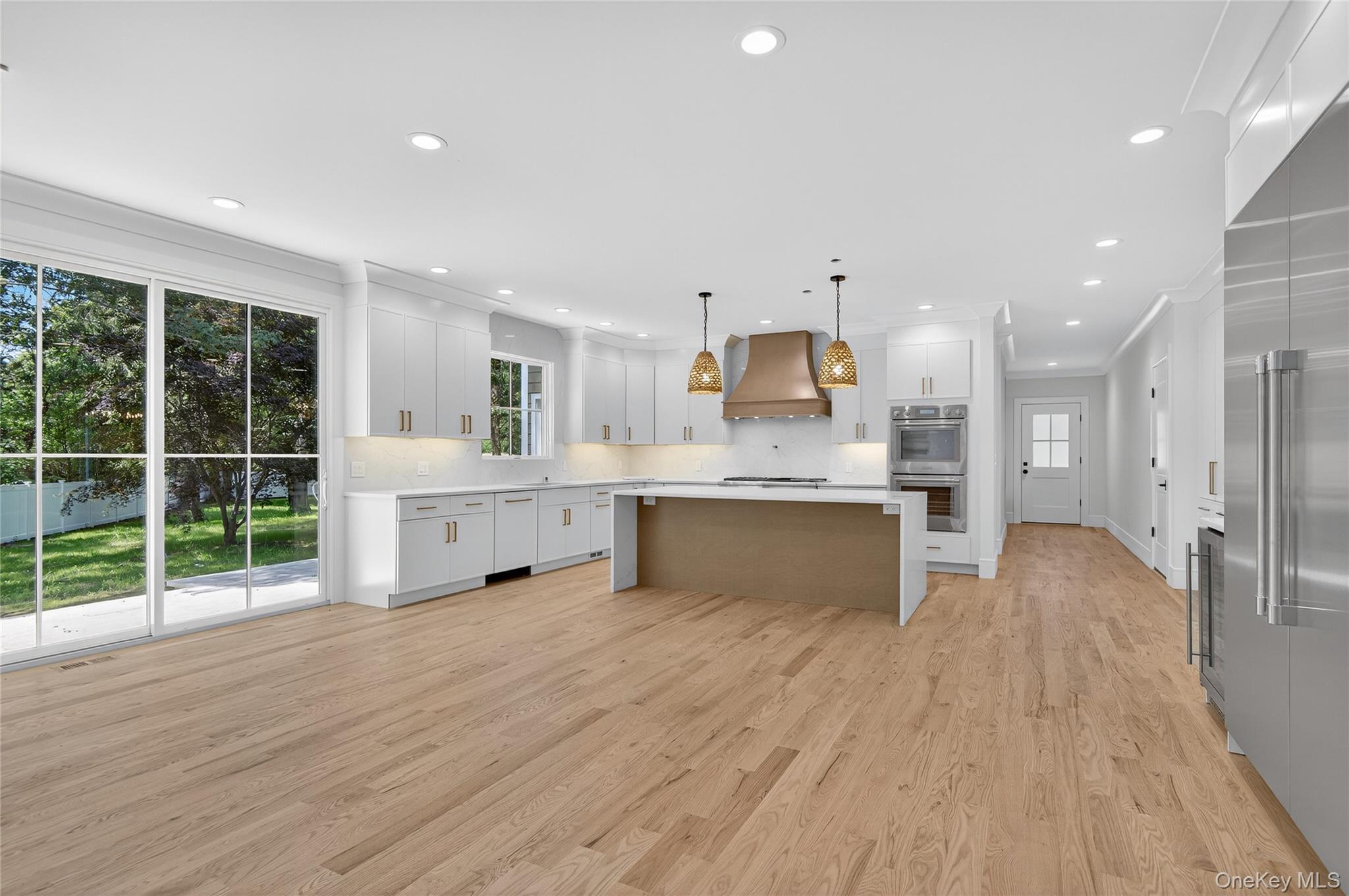 654 Caledonia Road Dix Hills, NY 11746 - Photo 12 of 42 Kitchen with white cabinets, hanging light fixtures, tasteful backsplash, light wood-style floors, and recessed lighting