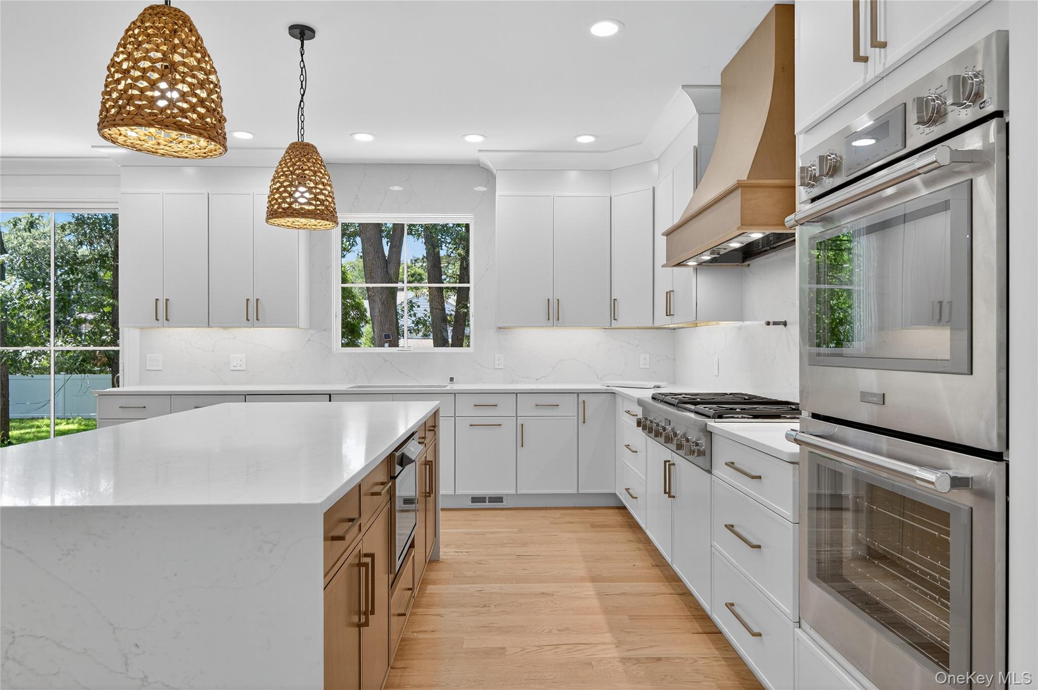 654 Caledonia Road Dix Hills, NY 11746 - Photo 16 of 42 Kitchen featuring stainless steel appliances, white cabinets, hanging light fixtures, light stone counters, and recessed lighting