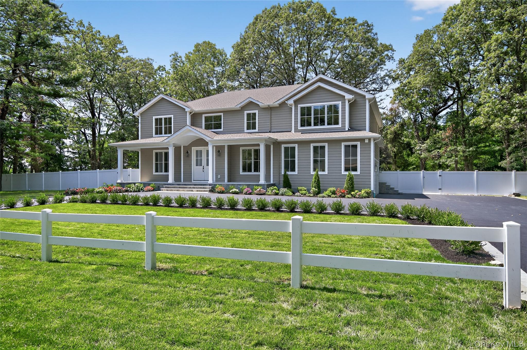 654 Caledonia Road Dix Hills, NY 11746 - Photo 2 of 42 View of front of property featuring covered porch, view of scattered trees, and roof with shingles