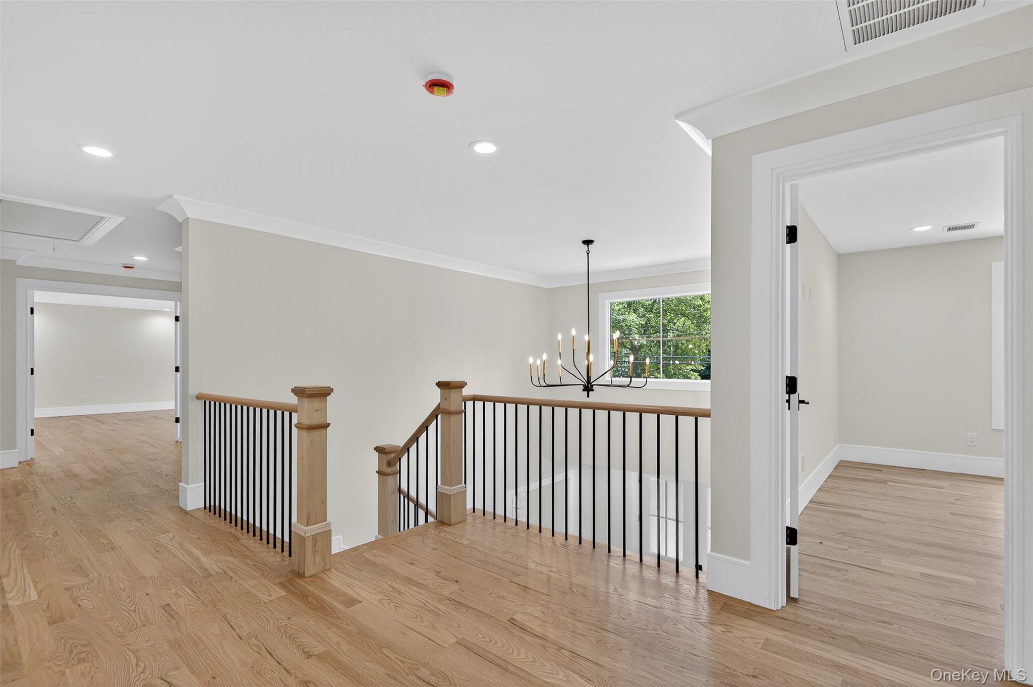 654 Caledonia Road Dix Hills, NY 11746 - Photo 21 of 42 Hall with attic access, light wood-style flooring, recessed lighting, a chandelier, and ornamental molding