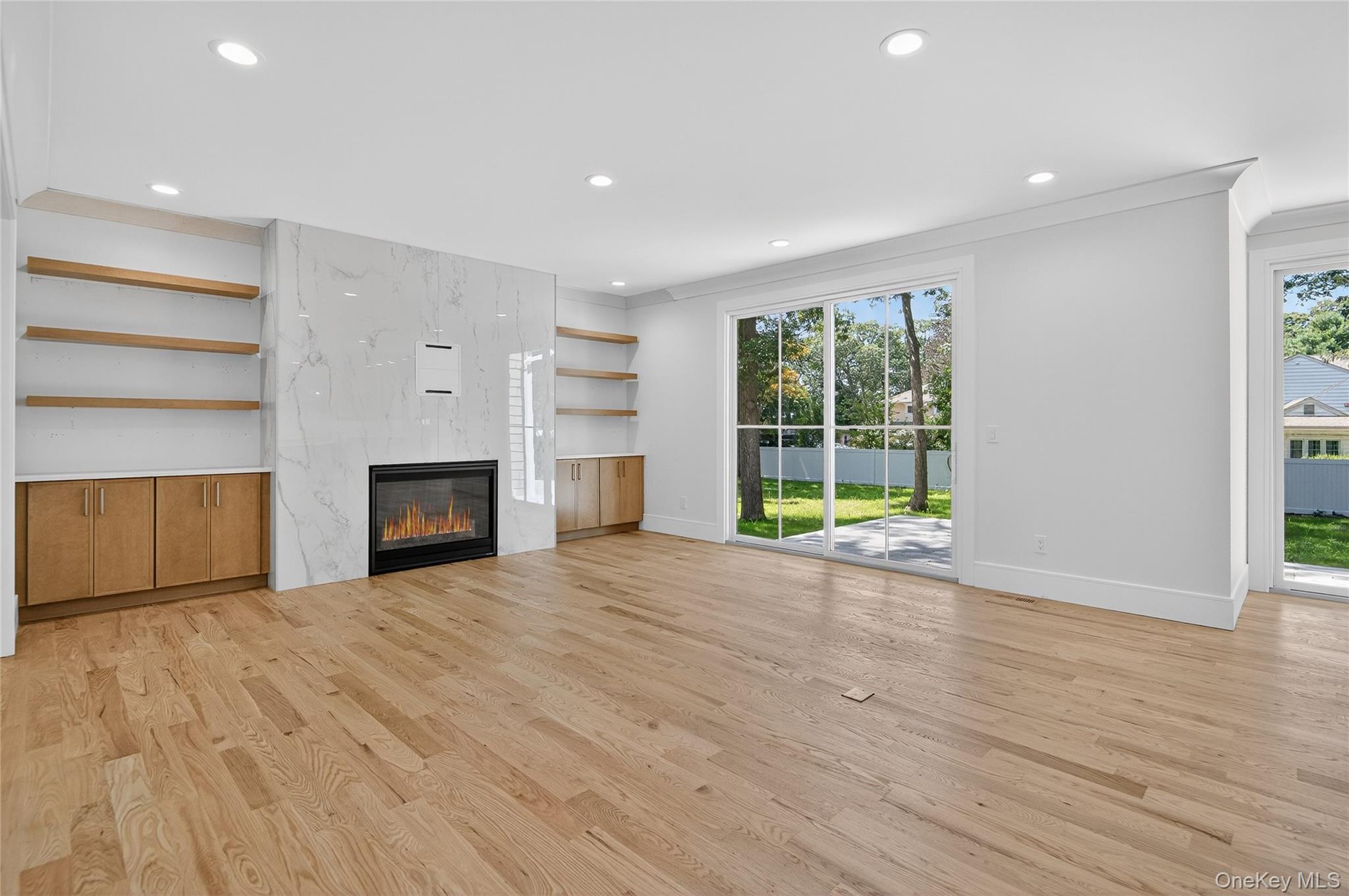 654 Caledonia Road Dix Hills, NY 11746 - Photo 8 of 42 Unfurnished living room with recessed lighting, light wood finished floors, a premium fireplace, and ornamental molding