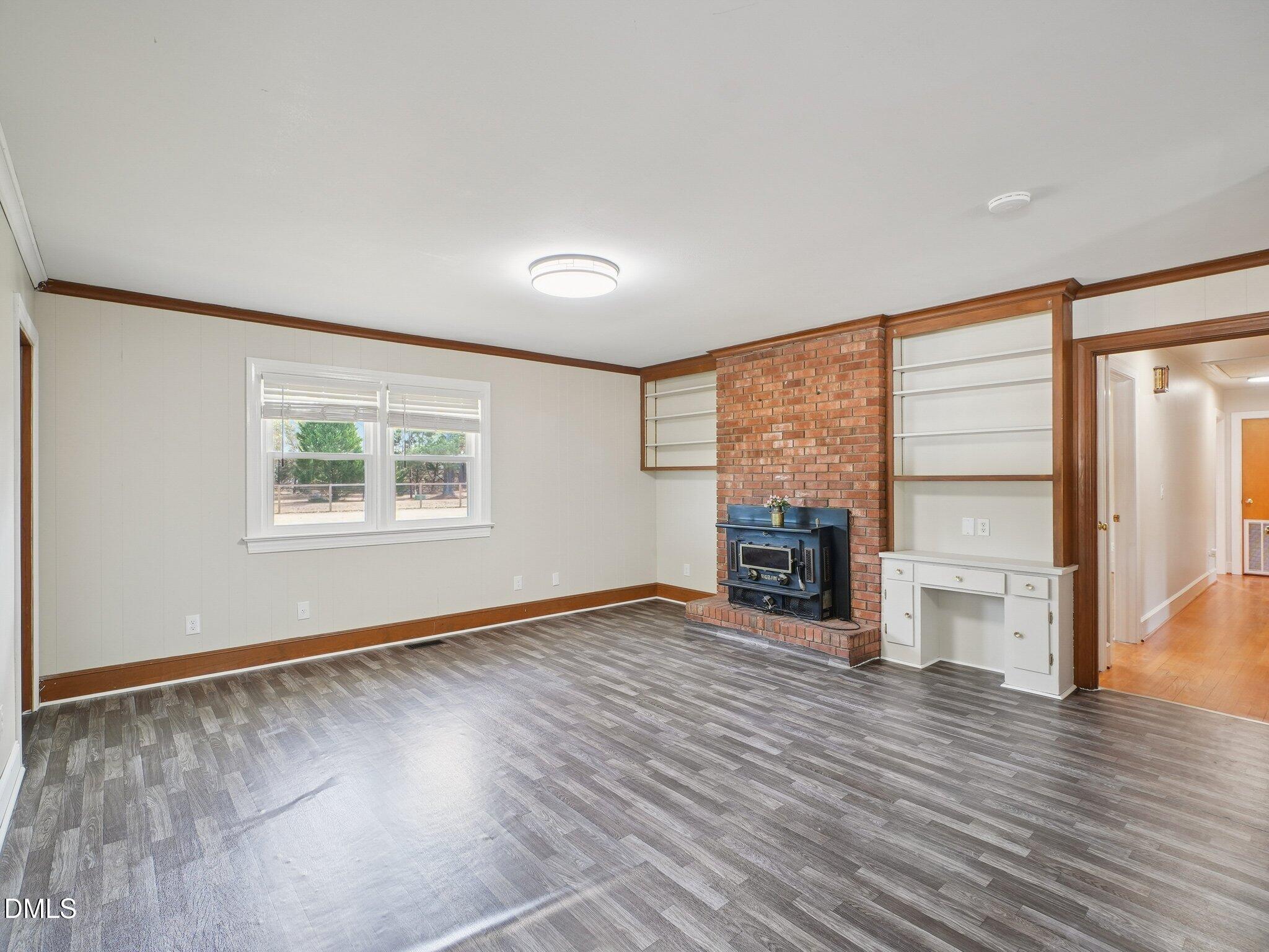 5474 Deans Road Battleboro, NC 27809 - Photo 3 of 32 an empty room with wooden floor fireplace and windows