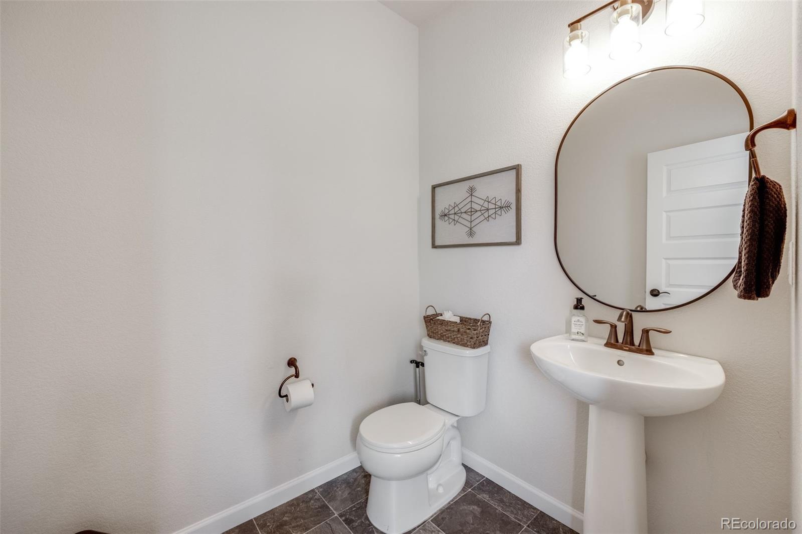 4811 River Highlands Loop Elizabeth, CO 80107 - Photo 14 of 37 a bathroom with a toilet sink and mirror