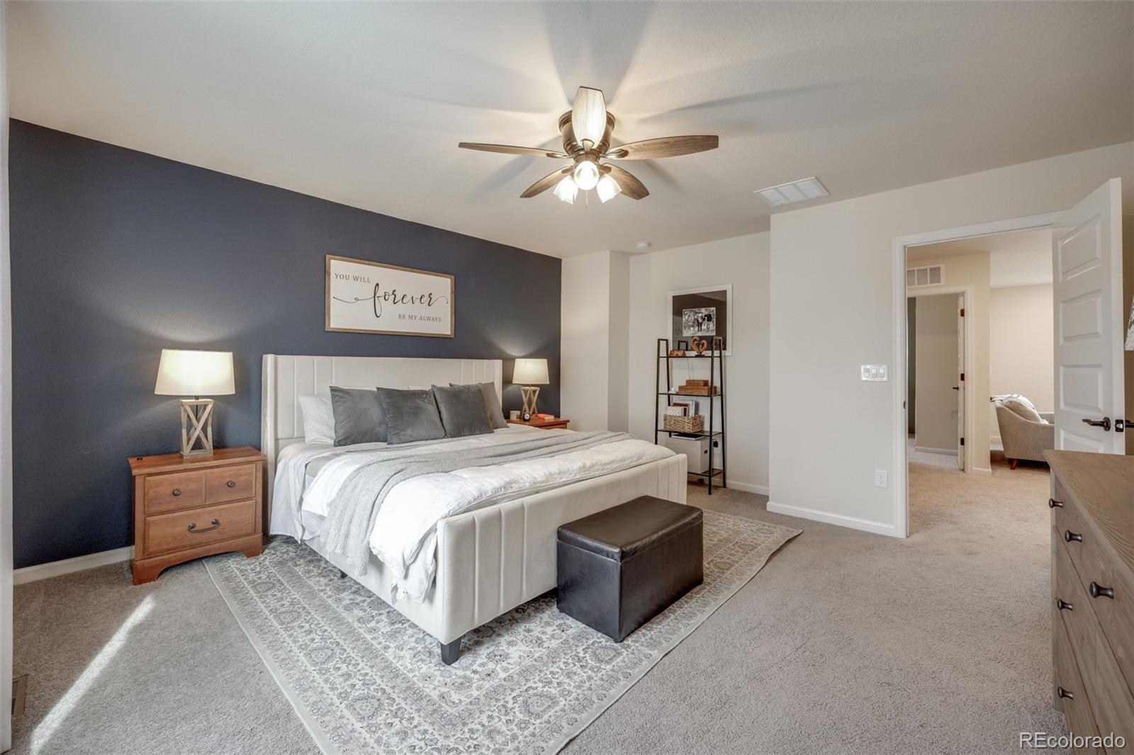 4811 River Highlands Loop Elizabeth, CO 80107 - Photo 19 of 37 a bedroom with a large bed and a chandelier