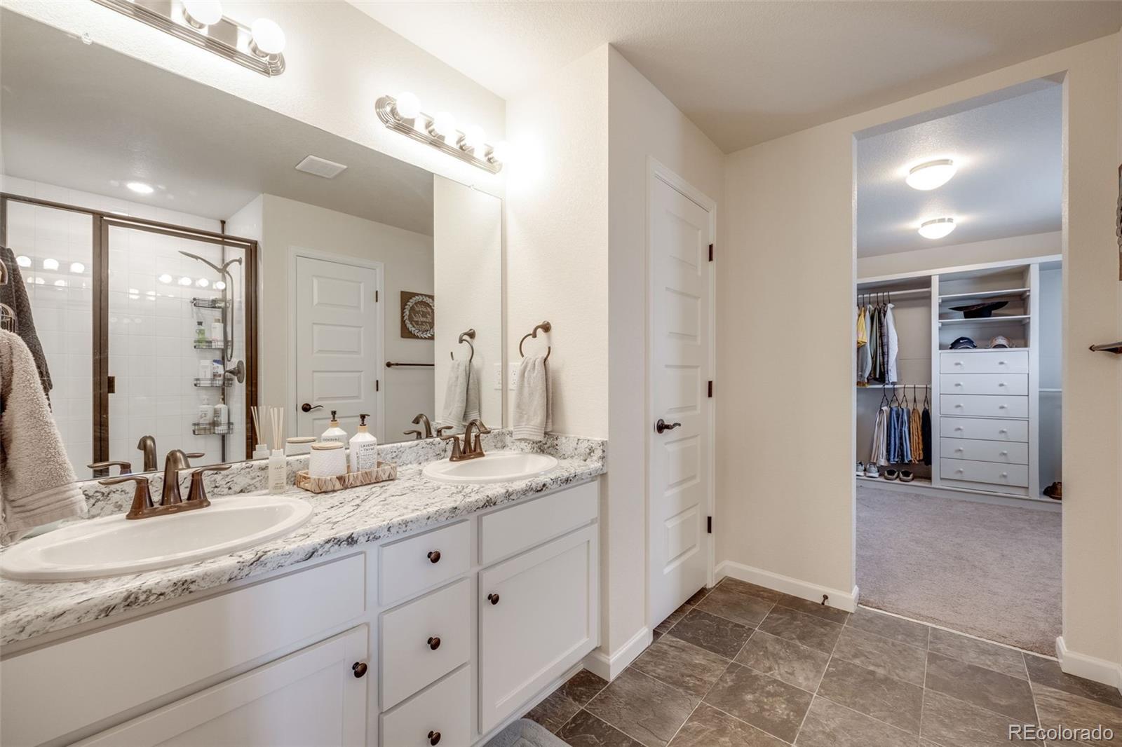4811 River Highlands Loop Elizabeth, CO 80107 - Photo 21 of 37 a spacious bathroom with a granite countertop sink mirror and shower