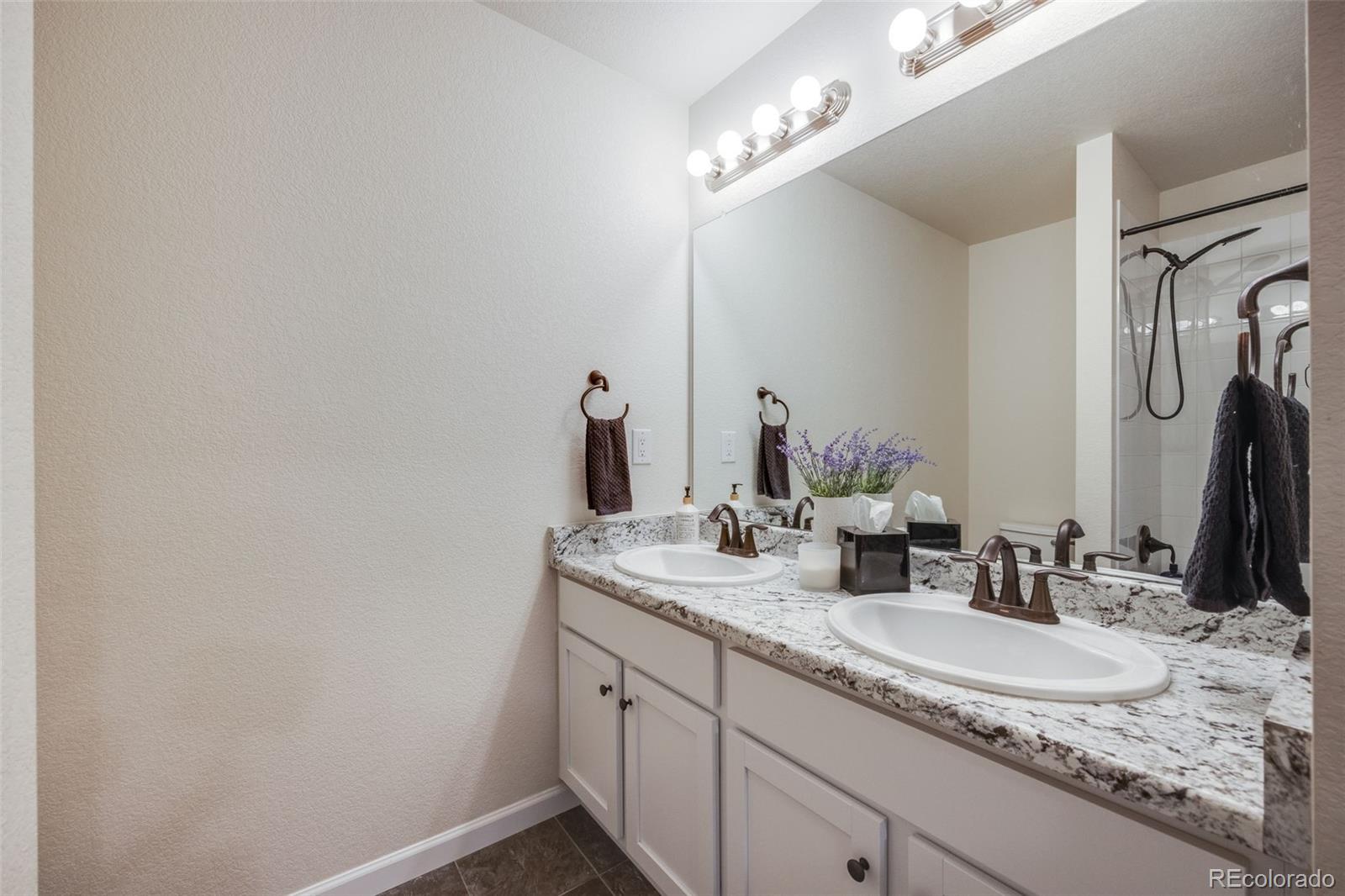 4811 River Highlands Loop Elizabeth, CO 80107 - Photo 24 of 37 a bathroom with a granite countertop sink and a mirror