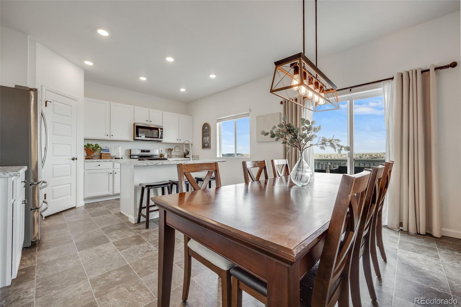 4811 River Highlands Loop Elizabeth, CO 80107 - Photo 10 of 37 a kitchen with stainless steel appliances granite countertop a stove a refrigerator a kitchen island a table and chairs