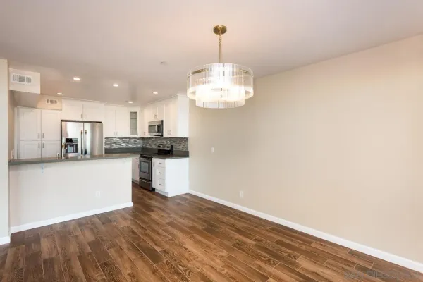a view of kitchen with granite countertop cabinets and refrigerator