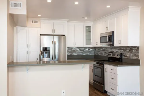 a kitchen with stainless steel appliances granite countertop a refrigerator and a stove