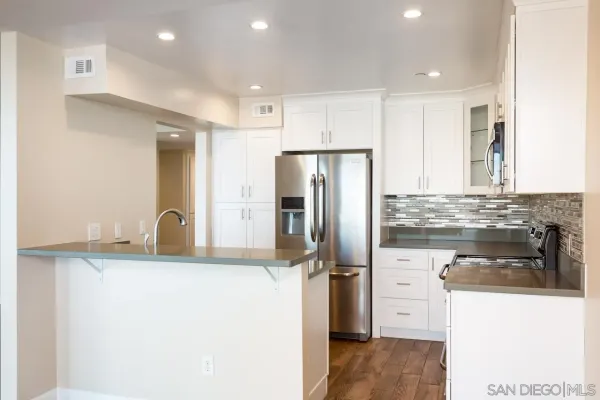 a kitchen with kitchen island granite countertop a refrigerator stove and sink