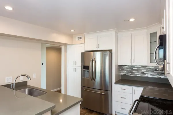 a kitchen with granite countertop a refrigerator and a sink