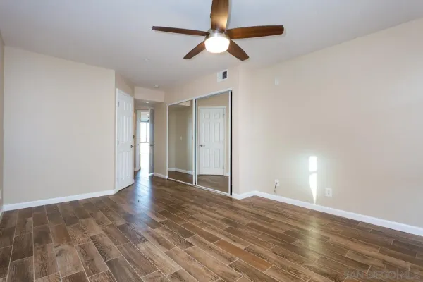 a view of an empty room with wooden floor