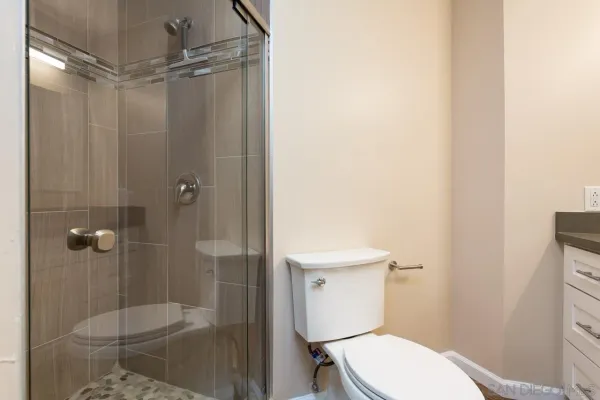 a white toilet sitting next to a shower