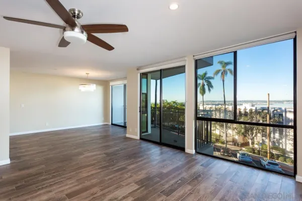 an empty room with wooden floor and windows