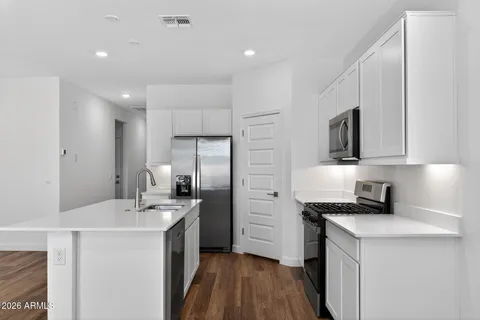 a kitchen with stainless steel appliances a sink stove and refrigerator