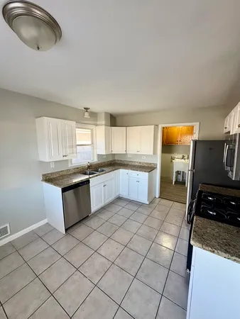 a large kitchen with a stove a sink dishwasher and a refrigerator