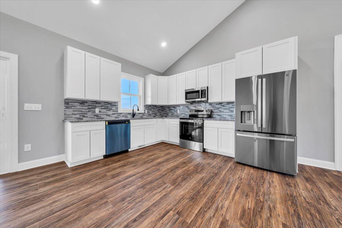 224 Marshall Mill Road Gladys, VA 24554 - Photo 10 of 38 a kitchen with a refrigerator a stove top oven a microwave and cabinets