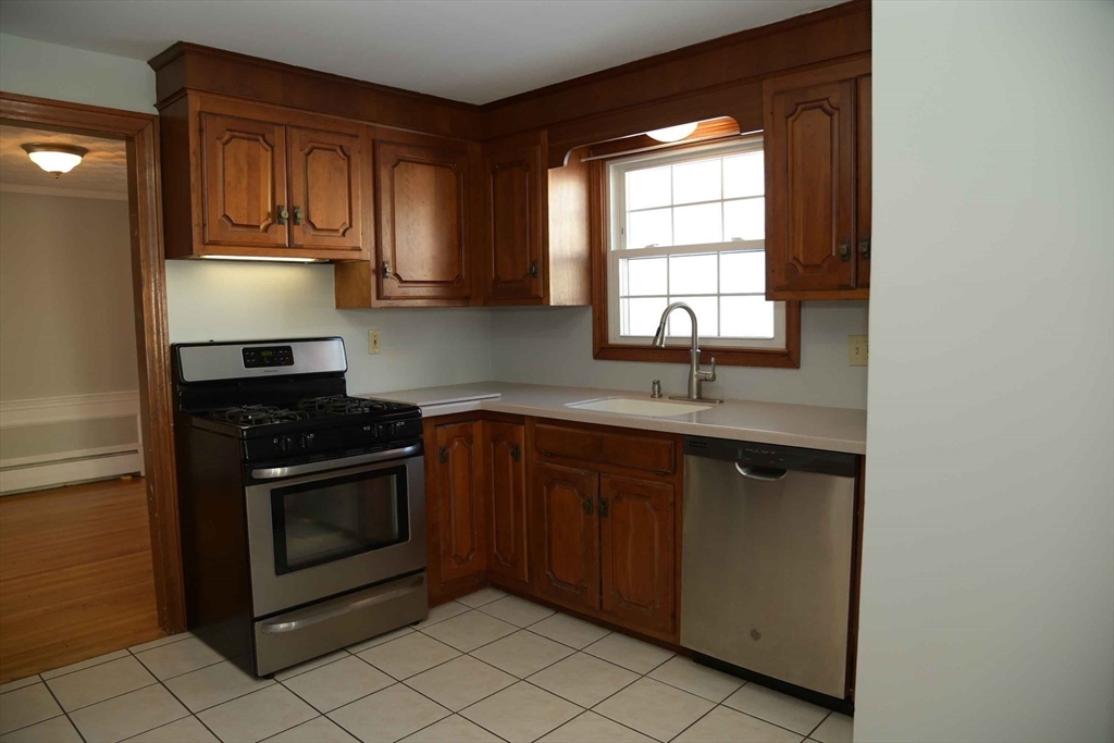 15 Highfield Road Boston, MA 02131 - Photo 14 of 41 a kitchen with stainless steel appliances granite countertop a sink stove and microwave