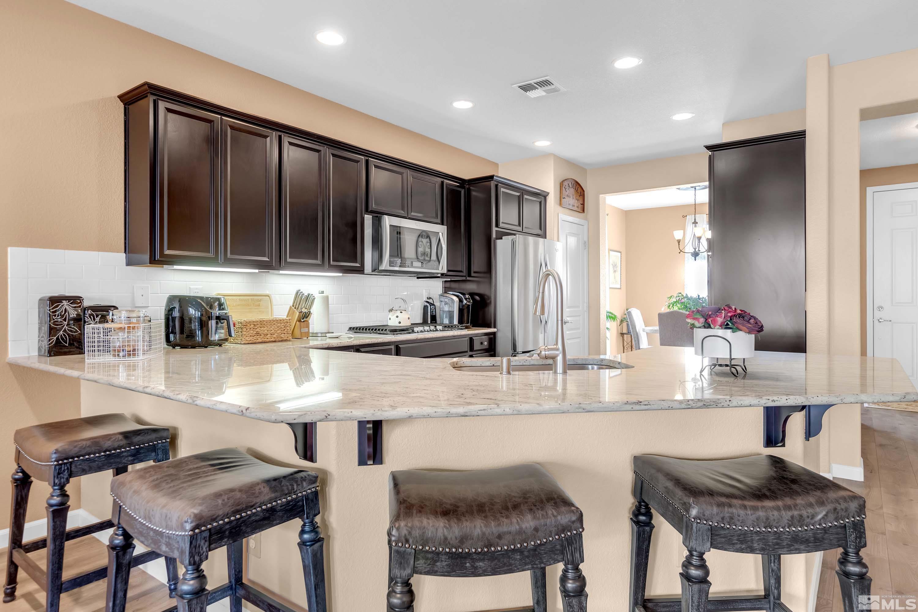 895 Larrimore Trail Reno, NV 89523 - Photo 12 of 39 a kitchen with granite countertop a table and chairs in it