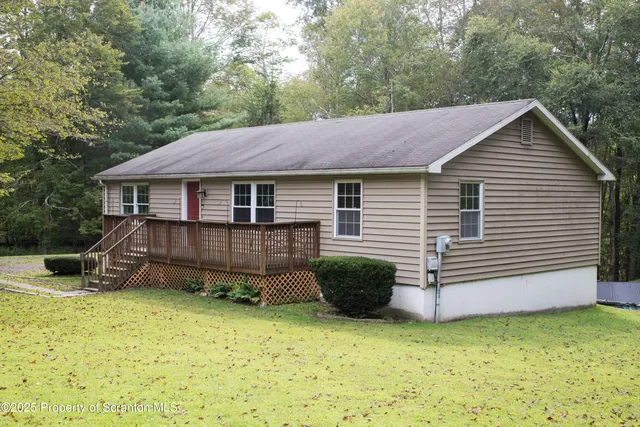 a backyard of a house with plants and wooden fence
