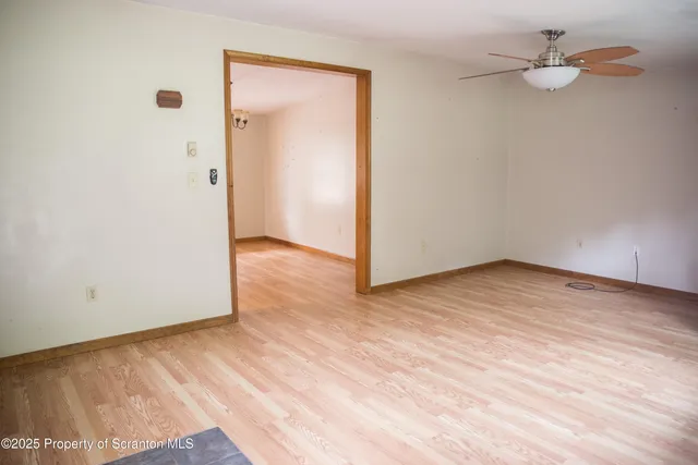 a view of empty room with wooden floor