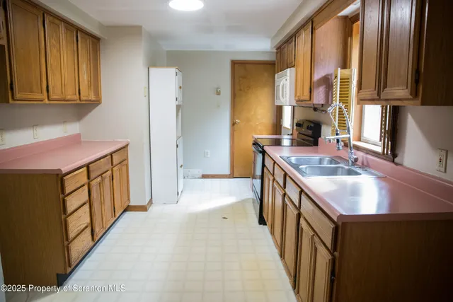a kitchen with a sink stove top oven and refrigerator