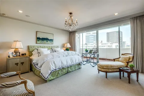 a spacious bedroom with a bed and a chandelier