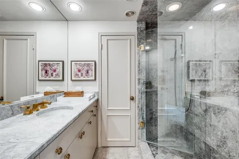 a bathroom with a granite countertop sink mirror and shower