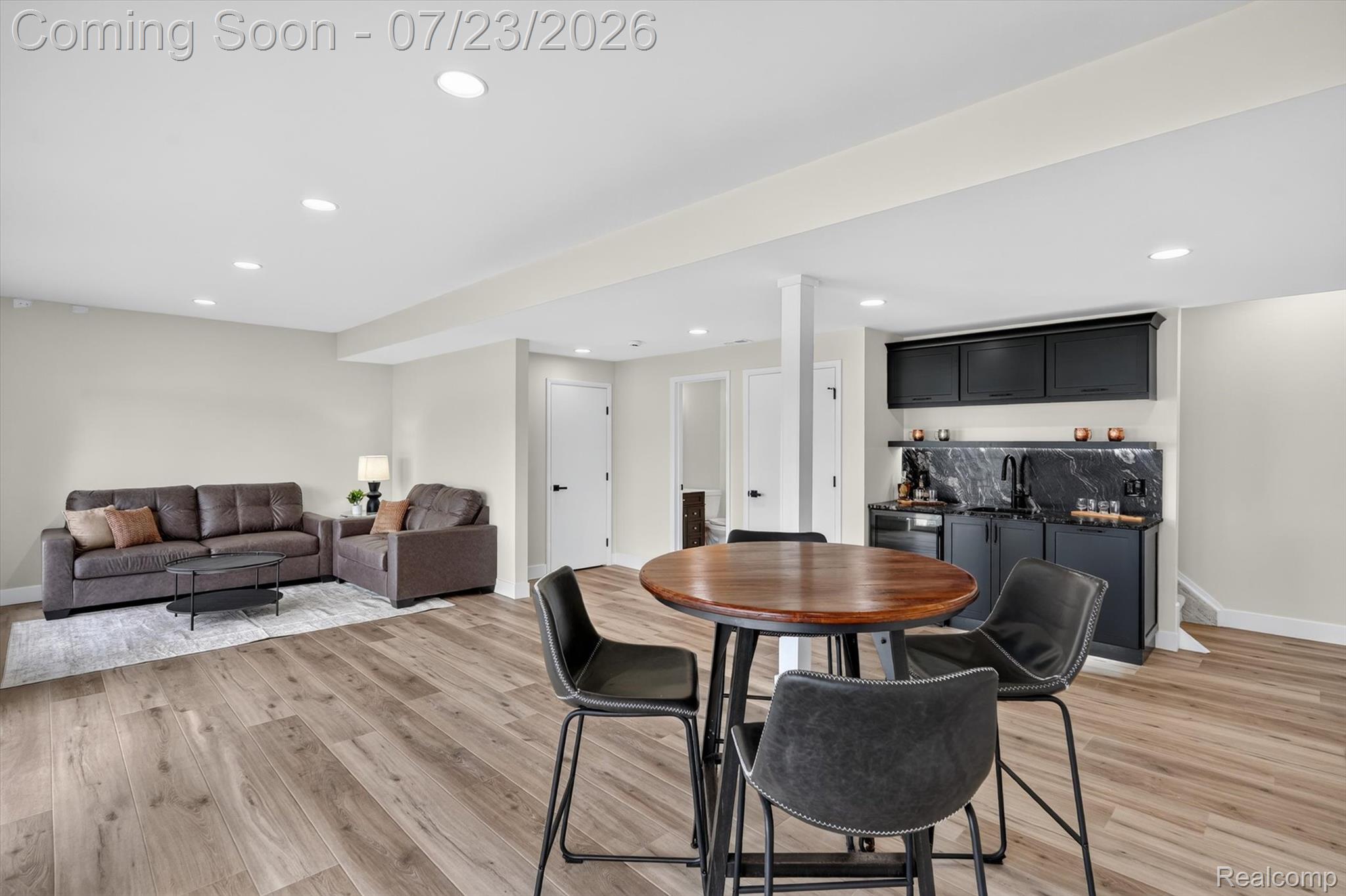 3429 Rolston Road Fenton, MI 48430 - Photo 39 of 62 Spacious finished lower level featuring wood-finish flooring, recessed lighting, and a wet bar with black cabinetry and a stone-patterned backsplash