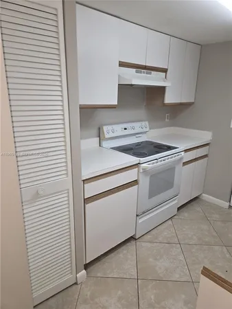 a white stove top oven sitting inside of a kitchen