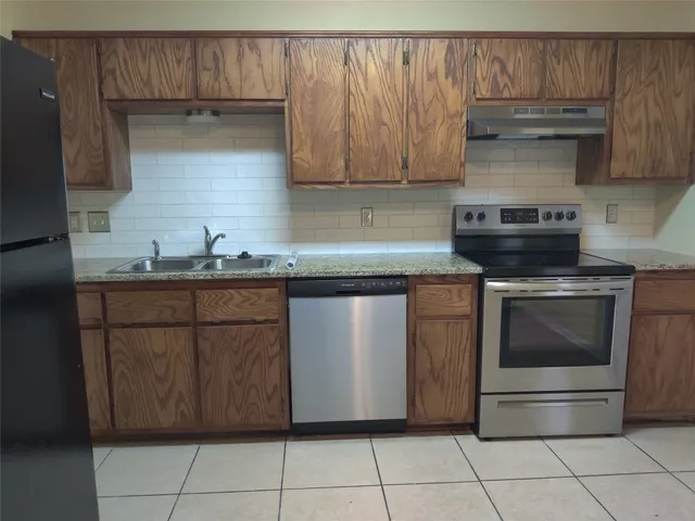 a kitchen with stainless steel appliances granite countertop a sink and a stove