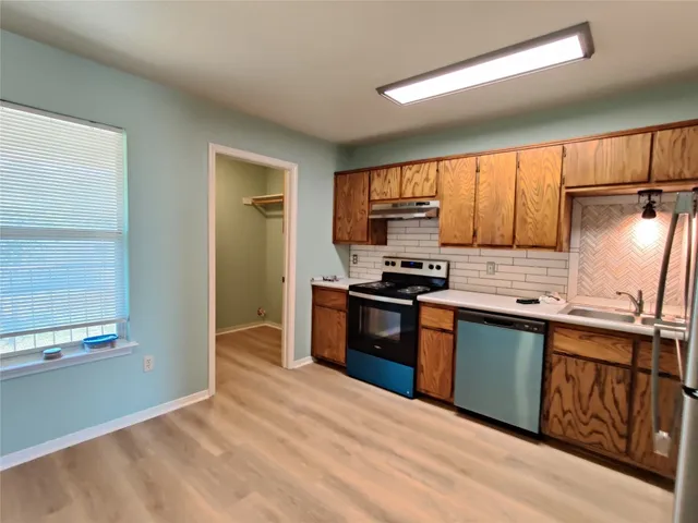 a kitchen with stainless steel appliances granite countertop a stove a sink and a refrigerator