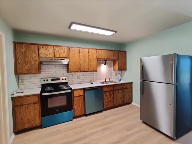 a kitchen with stainless steel appliances granite countertop a refrigerator stove and sink