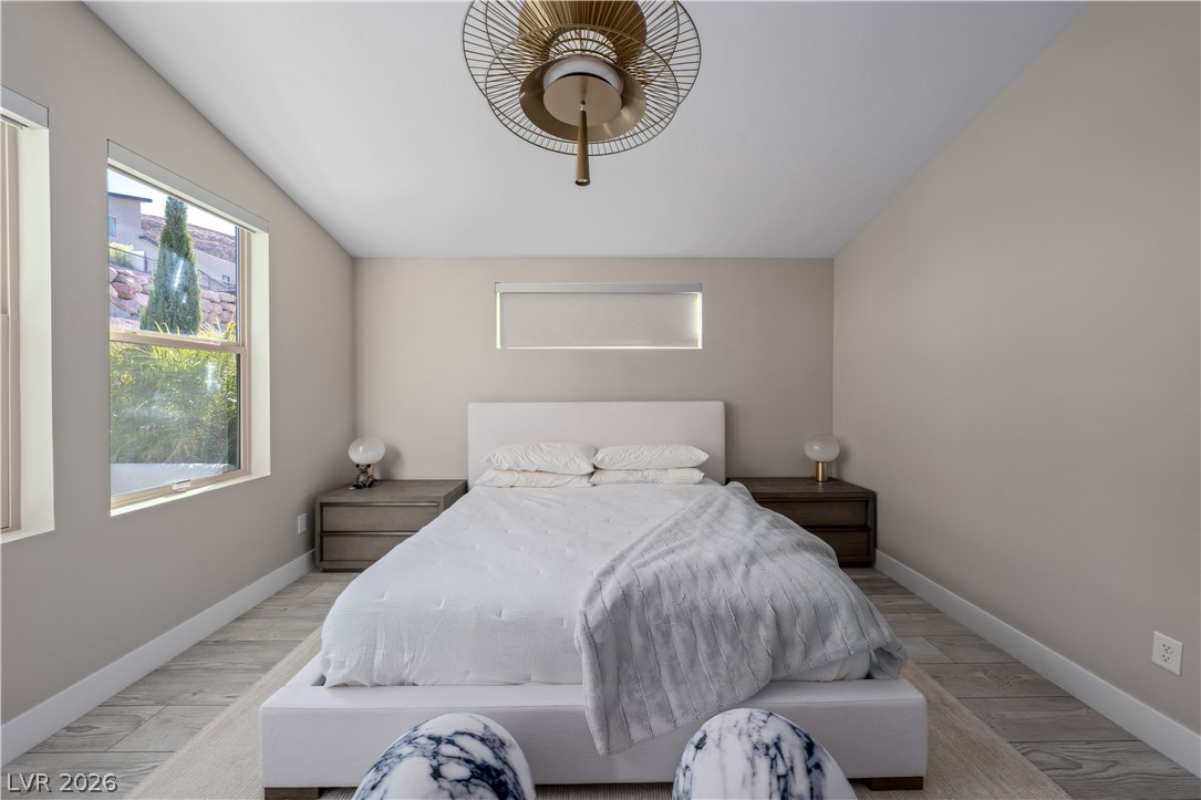 9719 Starlight Ridge Avenue Las Vegas, NV 89148 - Photo 11 of 27 Sloped ceilings and large windows create an airy, naturally illuminated primary bedroom retreat.
