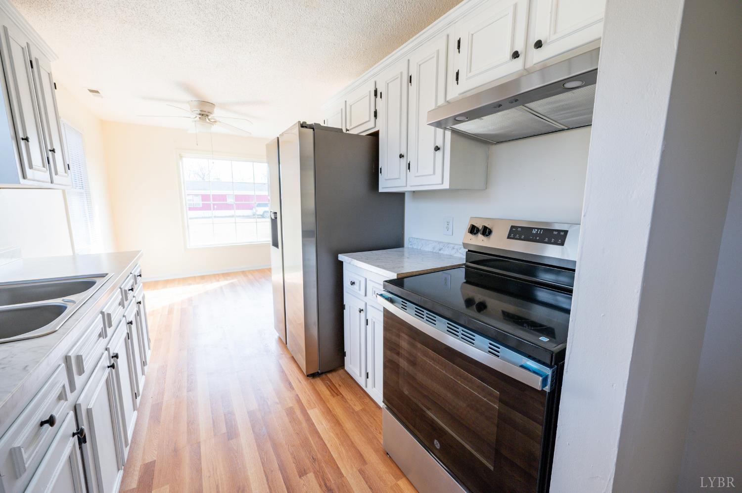 1114 Golden Leaf Road Nathalie, VA 24577 - Photo 11 of 32 a kitchen with stainless steel appliances a stove a refrigerator and cabinets