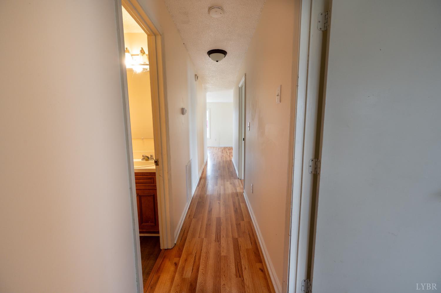 1114 Golden Leaf Road Nathalie, VA 24577 - Photo 20 of 32 a view of a hallway with wooden floor and a bathroom