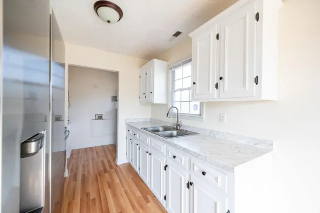 a kitchen with kitchen island granite countertop a sink and cabinets