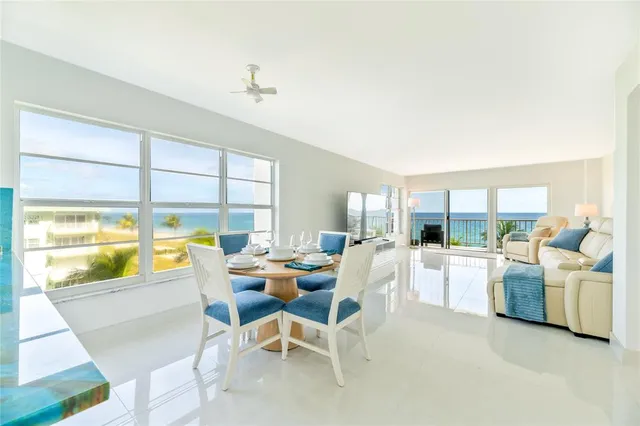 a room with lots of white furniture and a large window