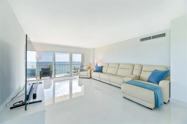 a living room with furniture and a floor to ceiling window