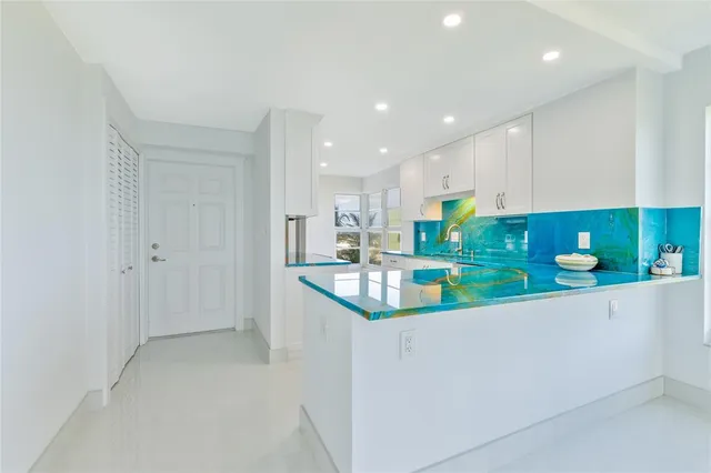 a kitchen with stainless steel appliances granite countertop a sink and a refrigerator