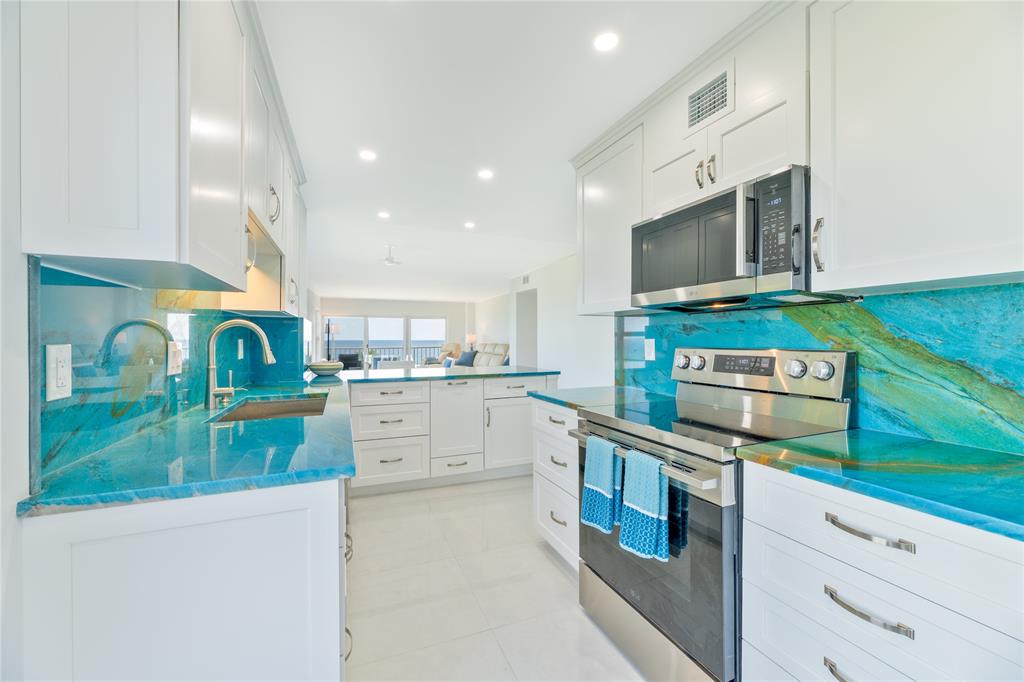 1021 Hillsboro Mile, Unit 308 Hillsboro Beach, FL 33062 - Photo 9 of 24 a kitchen with stainless steel appliances granite countertop a stove and a sink