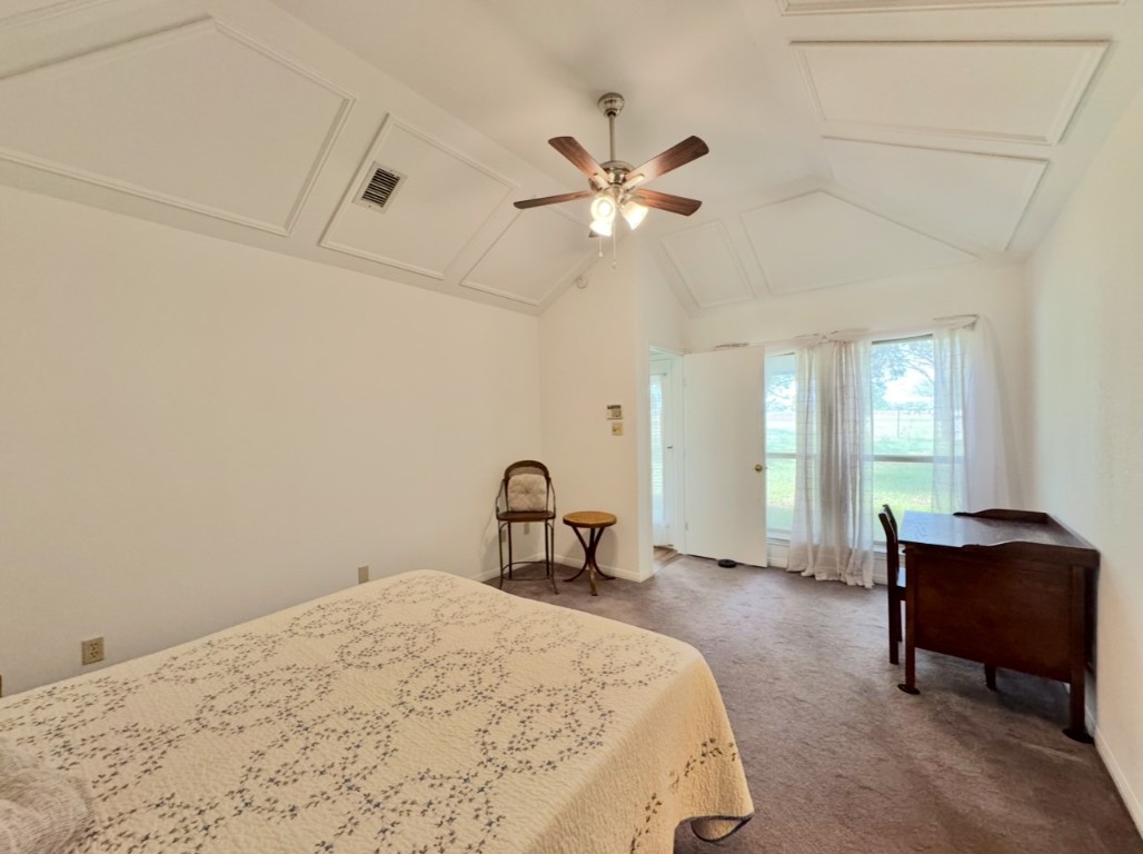 224 Crooked Hollow Road Elgin, TX 78621 - Photo 14 of 35 a bedroom with a bed and a chandelier