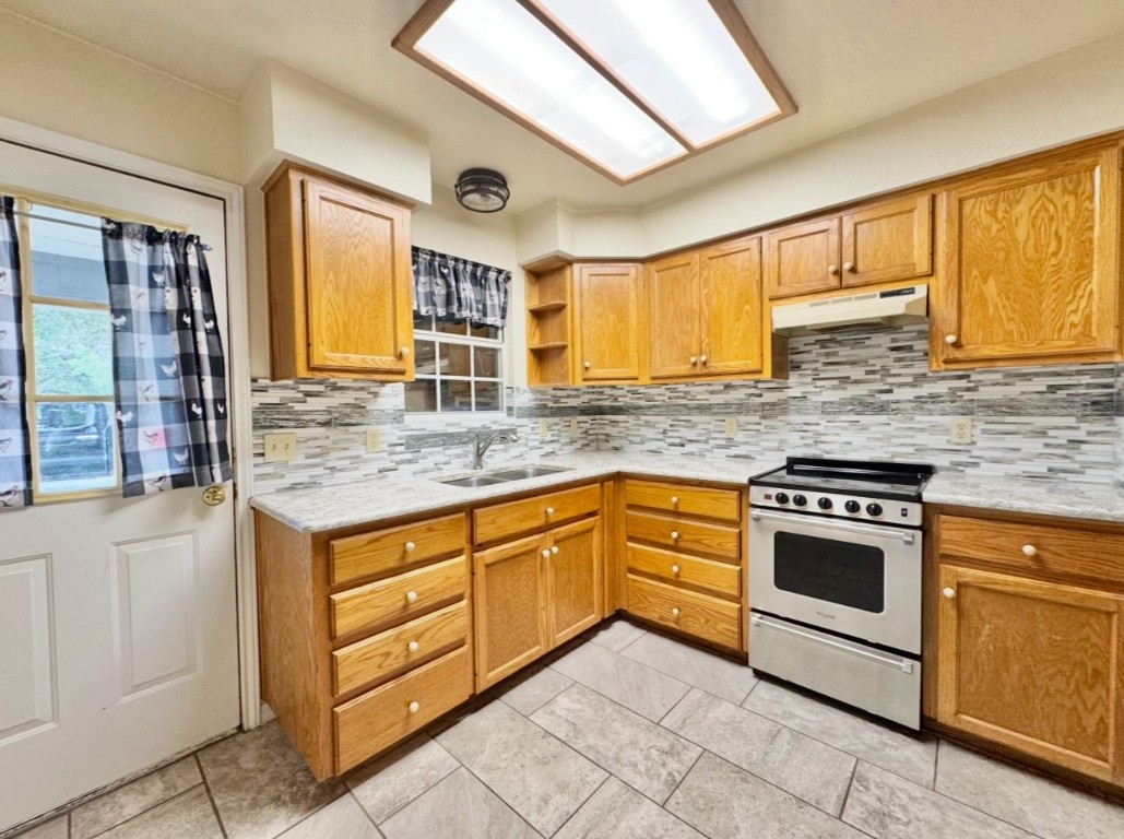 224 Crooked Hollow Road Elgin, TX 78621 - Photo 23 of 35 a kitchen with stainless steel appliances granite countertop a stove sink and cabinets