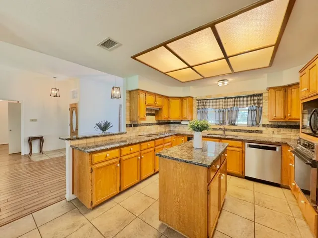 a kitchen with stainless steel appliances granite countertop sink stove top oven and cabinets